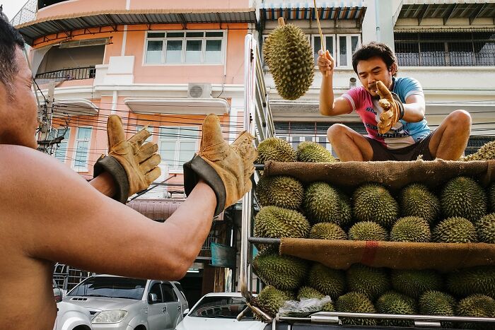 Two men handling durians from a truck in vibrant street photos capturing the soul of India by Rohit Vohra.