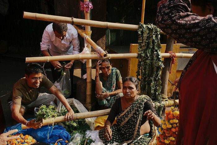 Street photo of Indian vendors selling fresh greens and marigold flowers, capturing the vibrant soul of India.