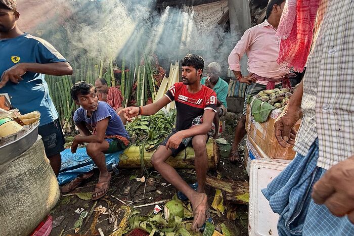 Street photo capturing daily life and vibrant market scenes in India with natural light filtering through the smoke.