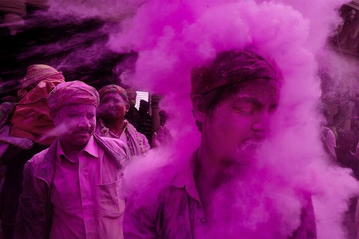 Men covered in vibrant pink powder during a powerful street photo capturing the soul of India by photographer Rohit Vohra.