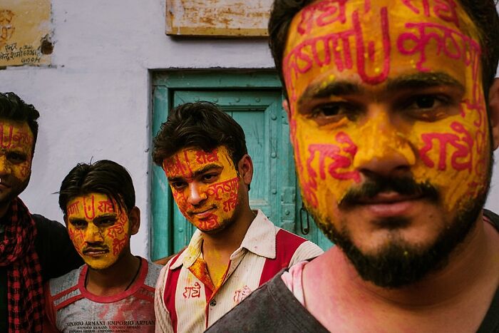 Group of young men with vibrant face paint in a powerful street photo capturing the soul of India by Rohit Vohra
