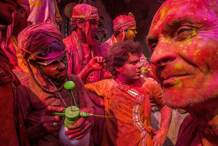 Men covered in vibrant colored powders celebrating Holi festival in a powerful street photo capturing the soul of India.