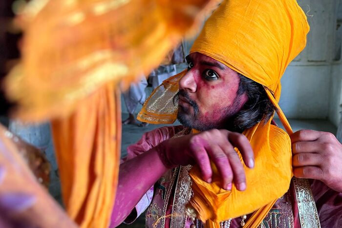 Young man in vibrant orange turban and traditional attire preparing for a cultural street photo in India by Rohit Vohra.