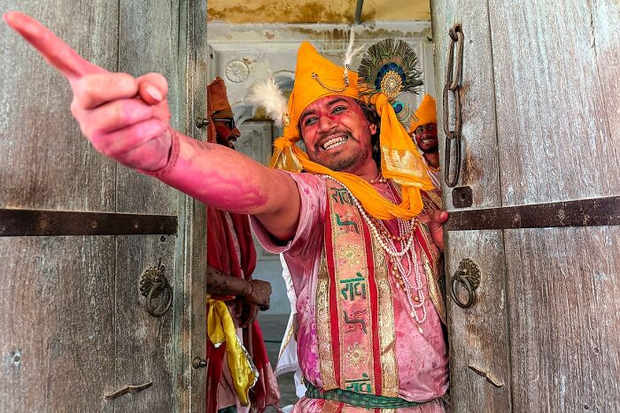 Colorful street photo of a joyful Indian man in traditional attire capturing the vibrant soul of India during a festival.