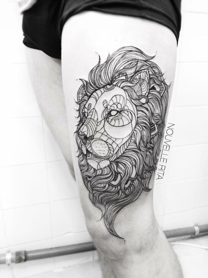 Intricate lion tattoo on thigh with detailed line work and abstract patterns, one of the best tattoos trending online.