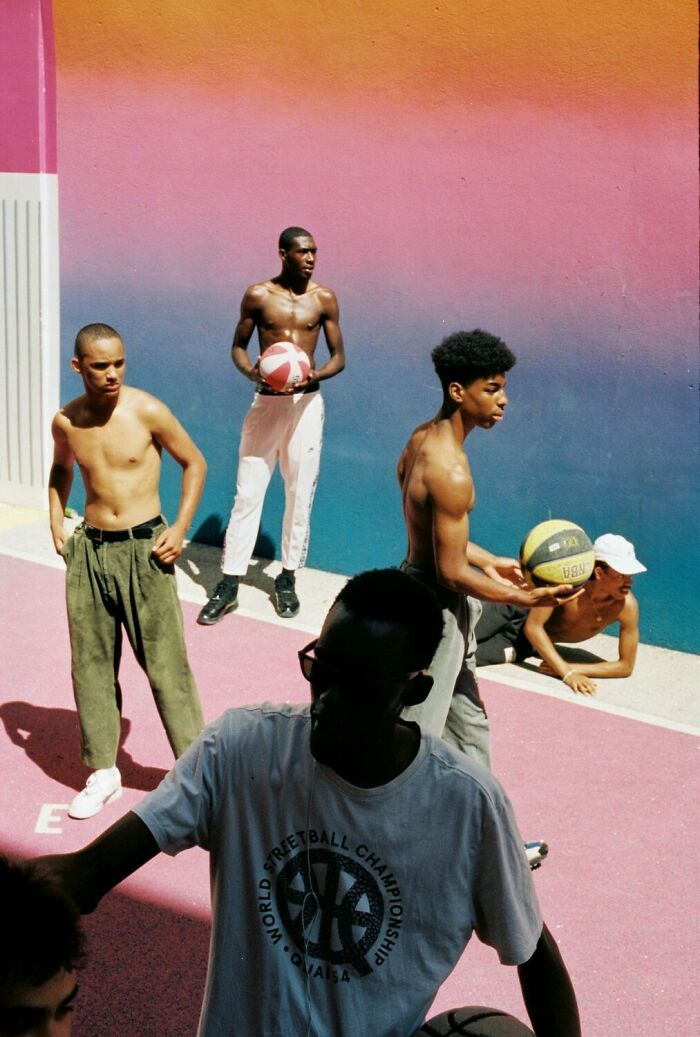 Group of young men playing basketball outdoors against a vibrant gradient wall showcasing the best color photography in 2025.