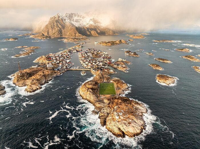 Aerial view of a coastal village and rocky islands showcasing breathtaking color photography landscape.