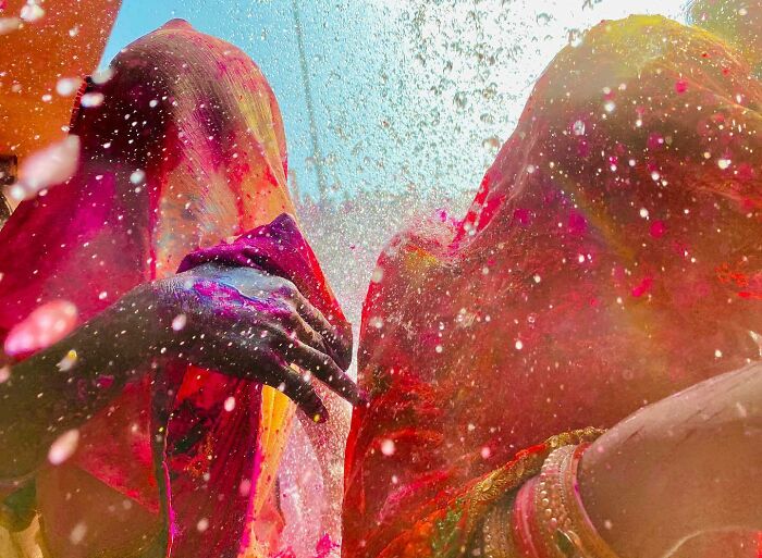 Two people covered in vibrant colors celebrating a traditional festival, showcasing stunning Asian culture photography.