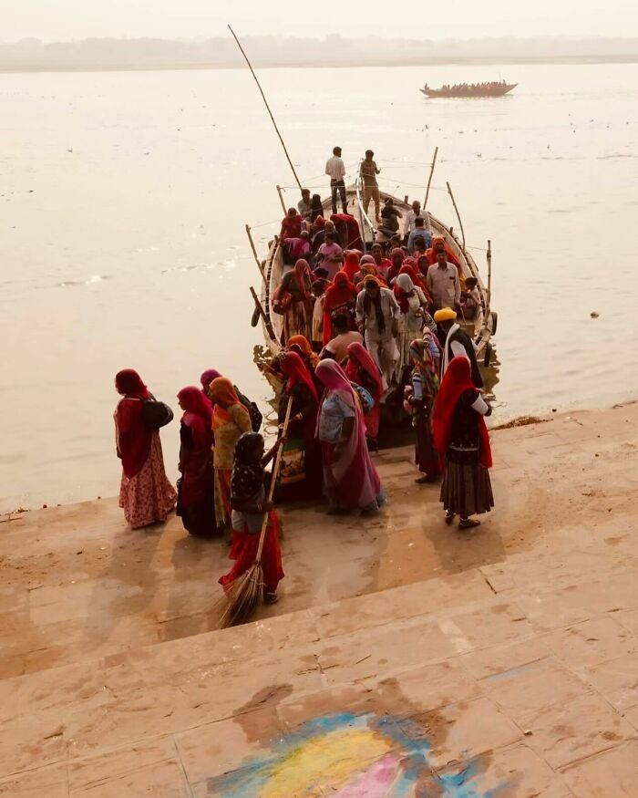 Group of people boarding a wooden boat by the riverbank, showcasing vibrant cultural scenes from exploring Asia.