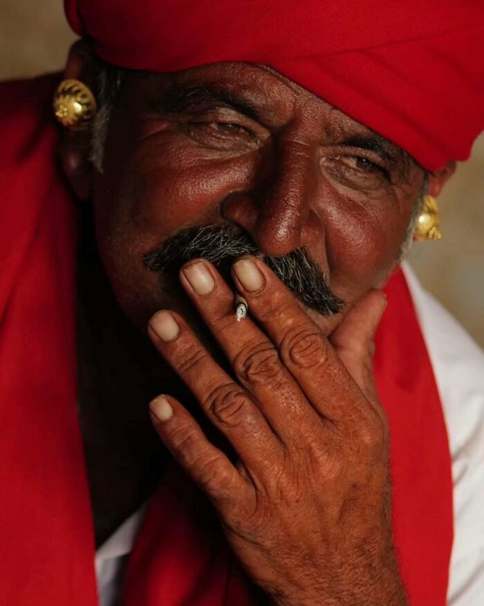 Close-up of an elderly man in traditional attire smoking, capturing the essence of photography exploring Asia.