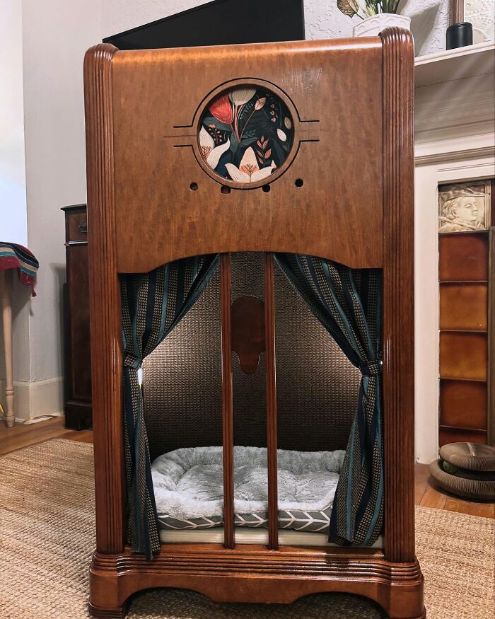 Vintage TV repurposed as a cozy cat bed with soft cushion and decorative curtains in a home setting.