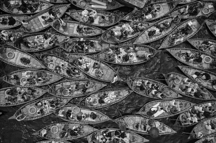Aerial shot of crowded boats on water filled with people, showcasing winning aerial photography from International Photographer of the Year.