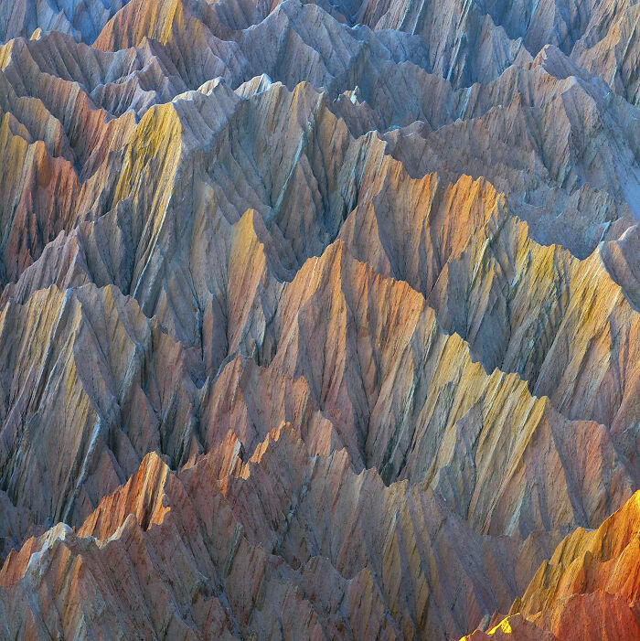 Colorful aerial shot of jagged mountain ridges showcasing unique formations in 100 winning aerial shots photography collection.