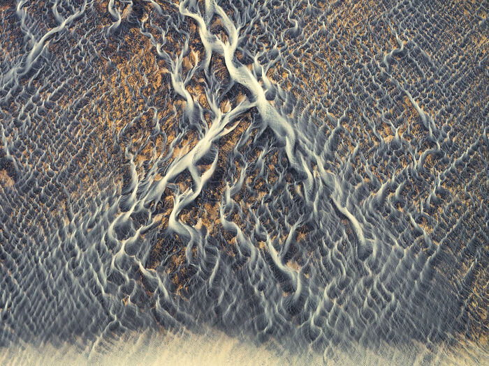 Abstract aerial shot of textured sand dunes with flowing patterns, featured in winning aerial shots by photographer 2025.