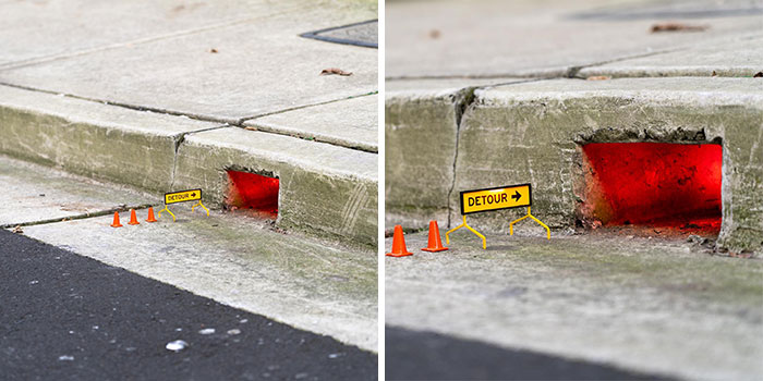 Miniature street scene with tiny detour sign and orange cones by a glowing red city gutter opening.
