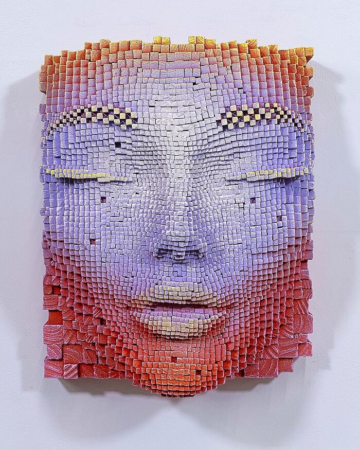 3D face sculpture made from wooden sticks, showing a detailed and hypnotic textured expression in vibrant colors.
