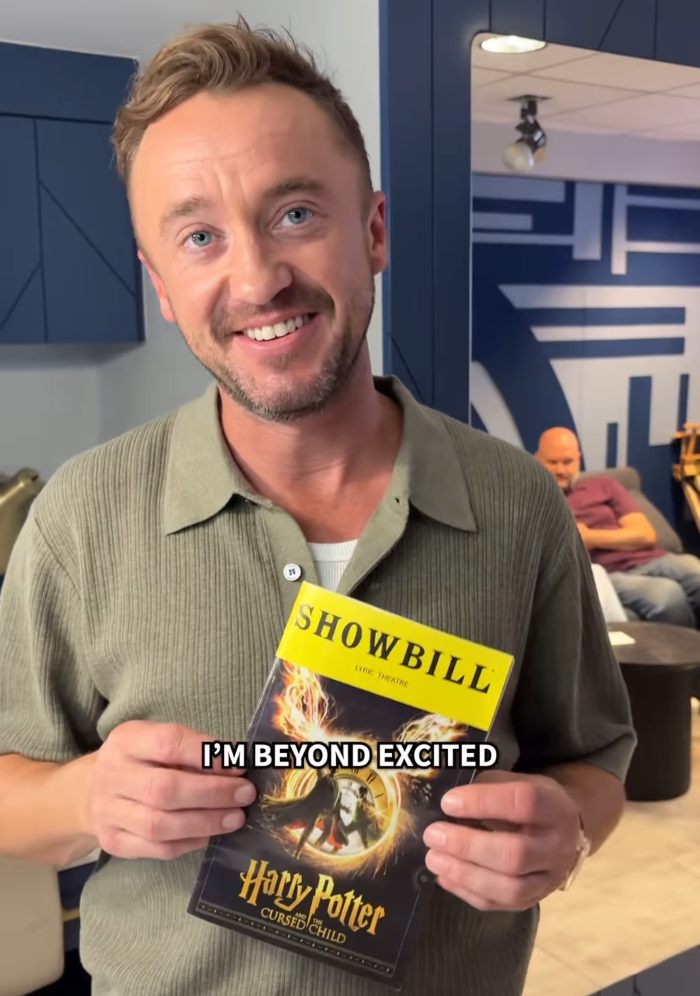 Actor holding a Harry Potter The Cursed Child showbill, smiling excitedly about a Harry Potter stars surprise reunion.