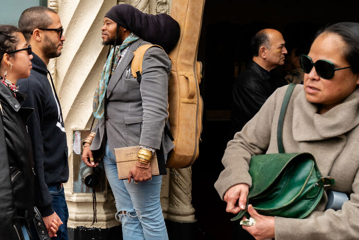 Street scene captured by photographer snapping coincidental moments in public with diverse people interacting naturally.