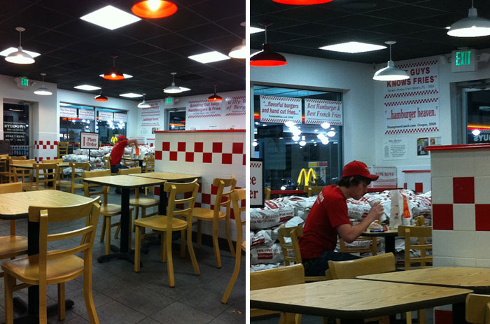 Employee working alone in a mostly empty restaurant, showing suspiciously unbothered attitude in everyday surroundings