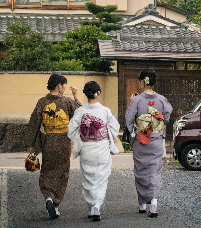 Three women wearing traditional kimonos walking on a street, illustrating cultural differences non-Americans do that confuse Americans. - 19