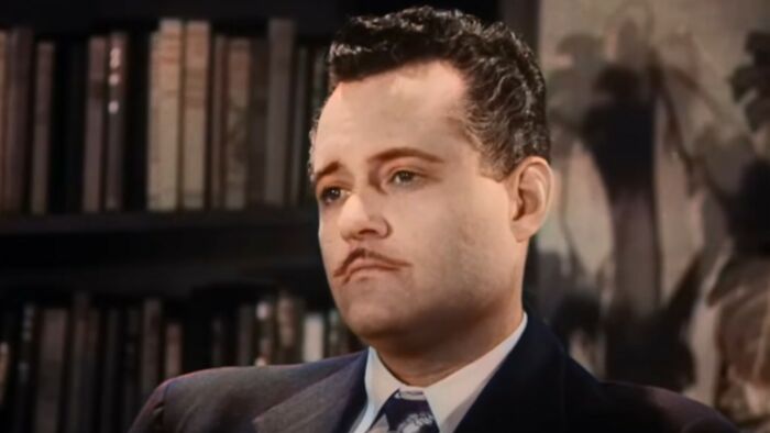 Man in vintage suit sitting thoughtfully in a study, representing the worst movies of all time theme.