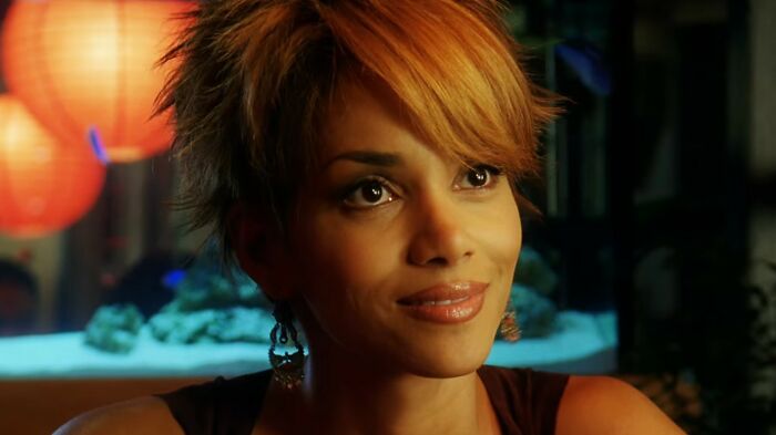 Actress with short hair smiling in a dimly lit scene from one of the worst movies of all time.