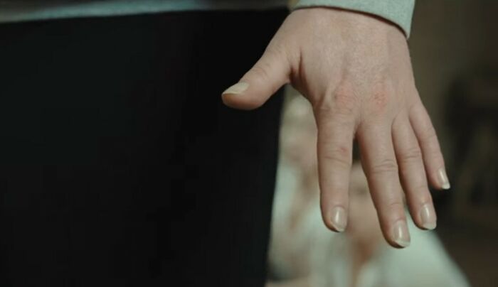 Close-up of a woman’s hand emphasizing nonverbal cues related to what makes a man instantly unattractive to women.