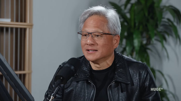 Man in glasses and black leather jacket speaking into a microphone during a discussion about Singapore experienced mass panic.