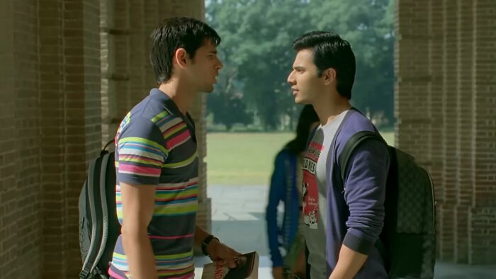 Two young men facing each other in a tense conversation, representing scenes from worst movies of all time.