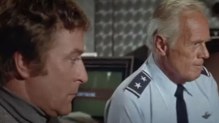 Two men in serious discussion, one in a military uniform, representing scenes from worst movies of all time.
