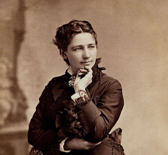 Victorian-era woman in thoughtful pose wearing dark dress, symbolizing journey from poverty to super wealthy status.