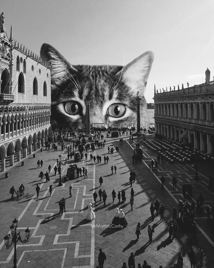 Surreal parallel universe scene with a giant cat looming over a busy city square filled with people.