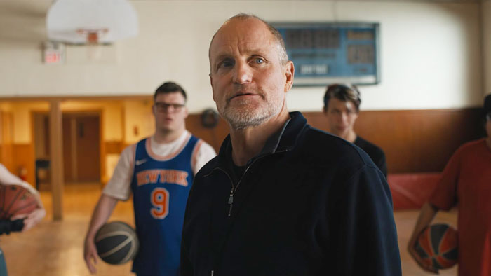 Woody Harrelson in gym setting, with basketball players in background, highlighting Woody Harrelson fans' surprising dad reveal. Woody Harrelson in gym setting, with basketball players in background, highlighting Woody Harrelson fans' surprising dad reveal.