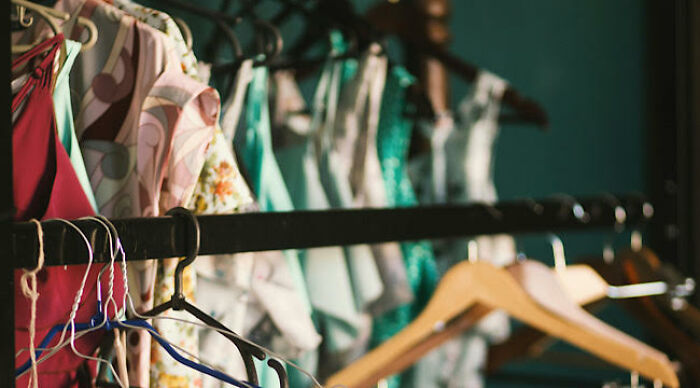 Clothes hanging on hangers in a closet with colorful dresses and empty hangers, illustrating worst movie tropes quiz concept.