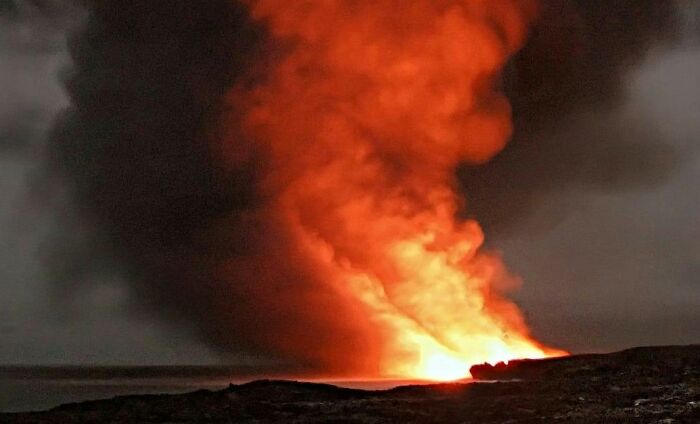 Volcanic eruption with bright orange lava and thick smoke, illustrating intense scenes for worst movie tropes quiz.