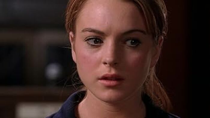 Close-up of a young woman with red hair looking concerned, illustrating common worst movie tropes in film scenes.