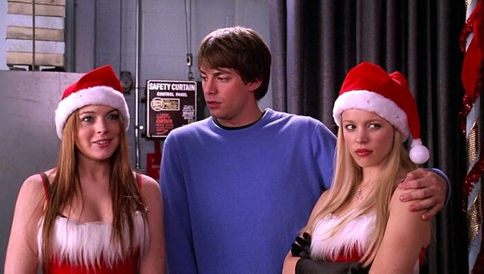 Three young adults in holiday costumes, with two wearing Santa hats, in a scene illustrating worst movie tropes quiz.