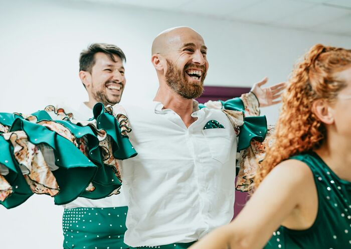 Three people smiling and dancing in a bright room, illustrating private investigators sharing their weirdest cases. - 4