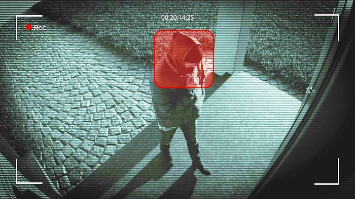 Surveillance footage of a person in a hoodie outside a building, related to messed up school incidents. - 14