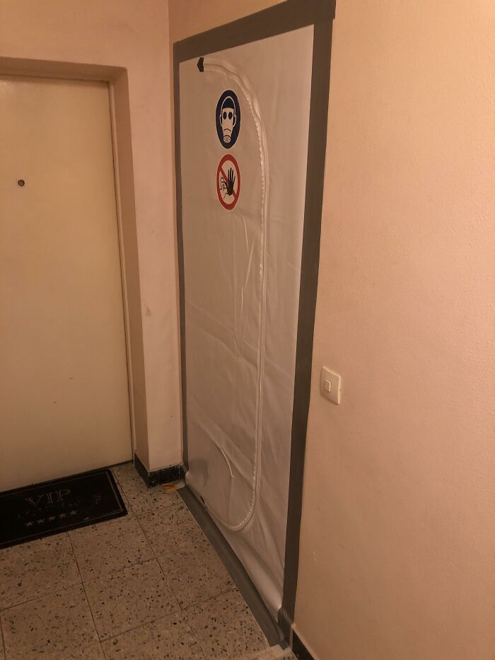 Plastic barrier with warning signs on an apartment wall, illustrating unusual neighbor tales that might make you want to move to the woods.