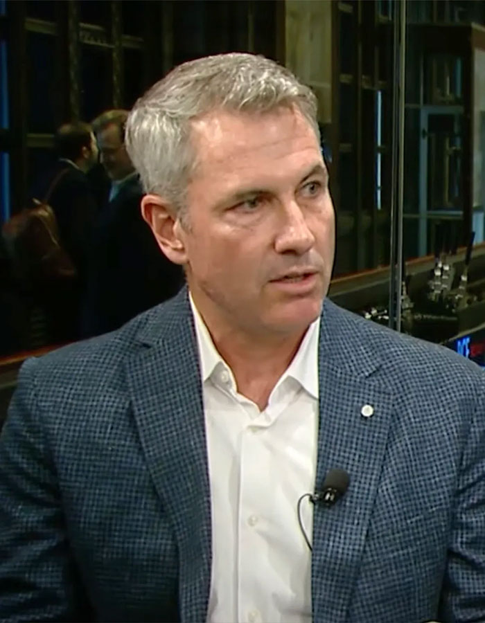 Astronomer CEO Andy Byron in a suit jacket and white shirt speaking during an interview in an indoor setting.