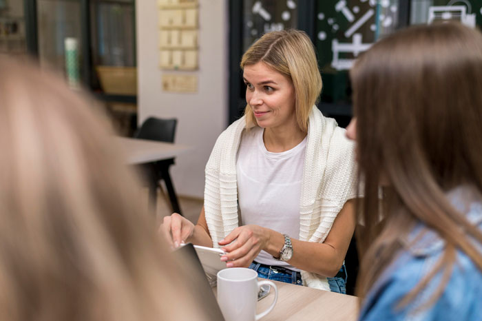 Woman discussing workplace issues with colleagues, highlighting ableist manager refusing disabled employee accommodations. Woman discussing workplace issues with colleagues, highlighting ableist manager refusing disabled employee accommodations.
