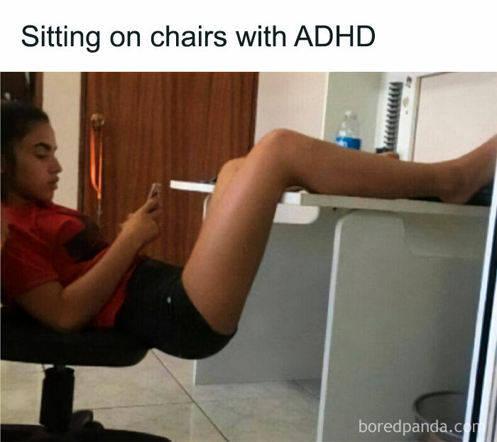 Person sitting oddly on a chair with legs on a desk, showing a relatable moment for neurodivergents with ADHD behaviors.