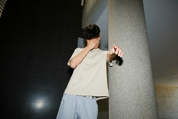 Person covering face with hand and pointing, illustrating hard-to-believe stories shared by people about themselves.