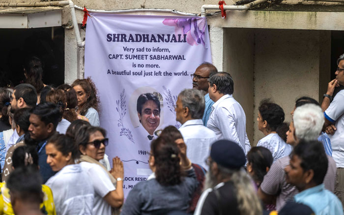 Mourners gathered at a memorial banner for Air India pilot Capt Sumeet Sabharwal amid personal turmoil and crash investigation. - 5