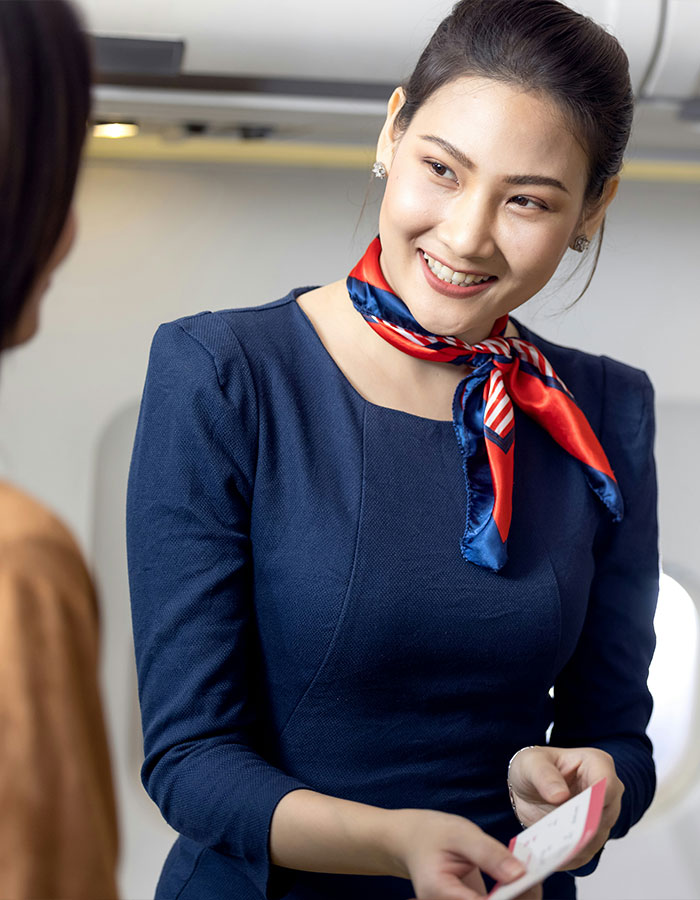 Flight attendant smiling and handing a ticket to a plane passenger during a seat dispute on a commercial flight. Flight attendant smiling and handing a ticket to a plane passenger during a seat dispute on a commercial flight.
