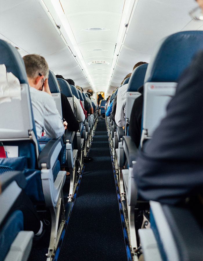 Interior view of airplane cabin showing passengers seated, illustrating a plane passenger upset over a child in his $300 seat. Interior view of airplane cabin showing passengers seated, illustrating a plane passenger upset over a child in his $300 seat.