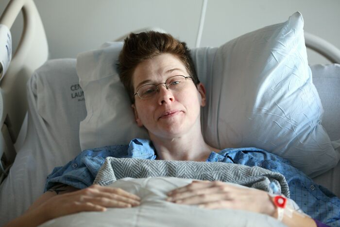 Woman resting in hospital bed after birth, reflecting the challenges and awful things women are told post childbirth.