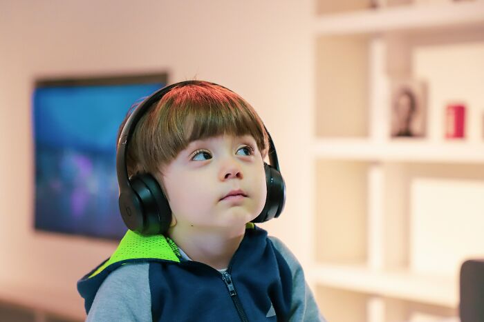 Young child wearing headphones indoors, illustrating bizarre beliefs people still fall for despite science busting myths. - 7