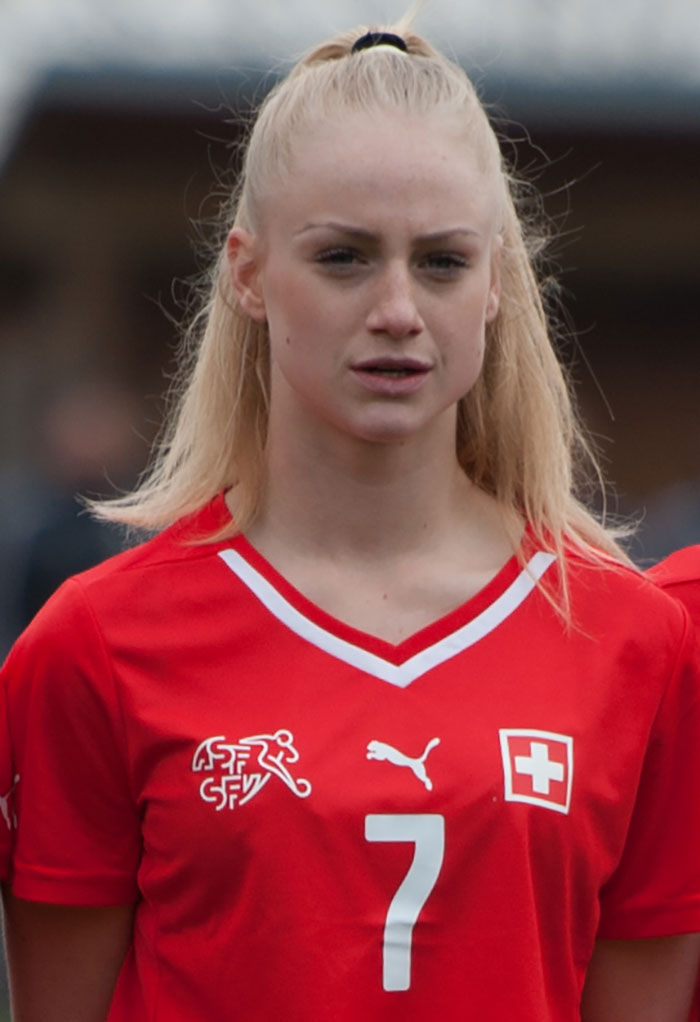 Female footballer wearing red jersey with number 7, representing world's prettiest footballer with stunning transformation.